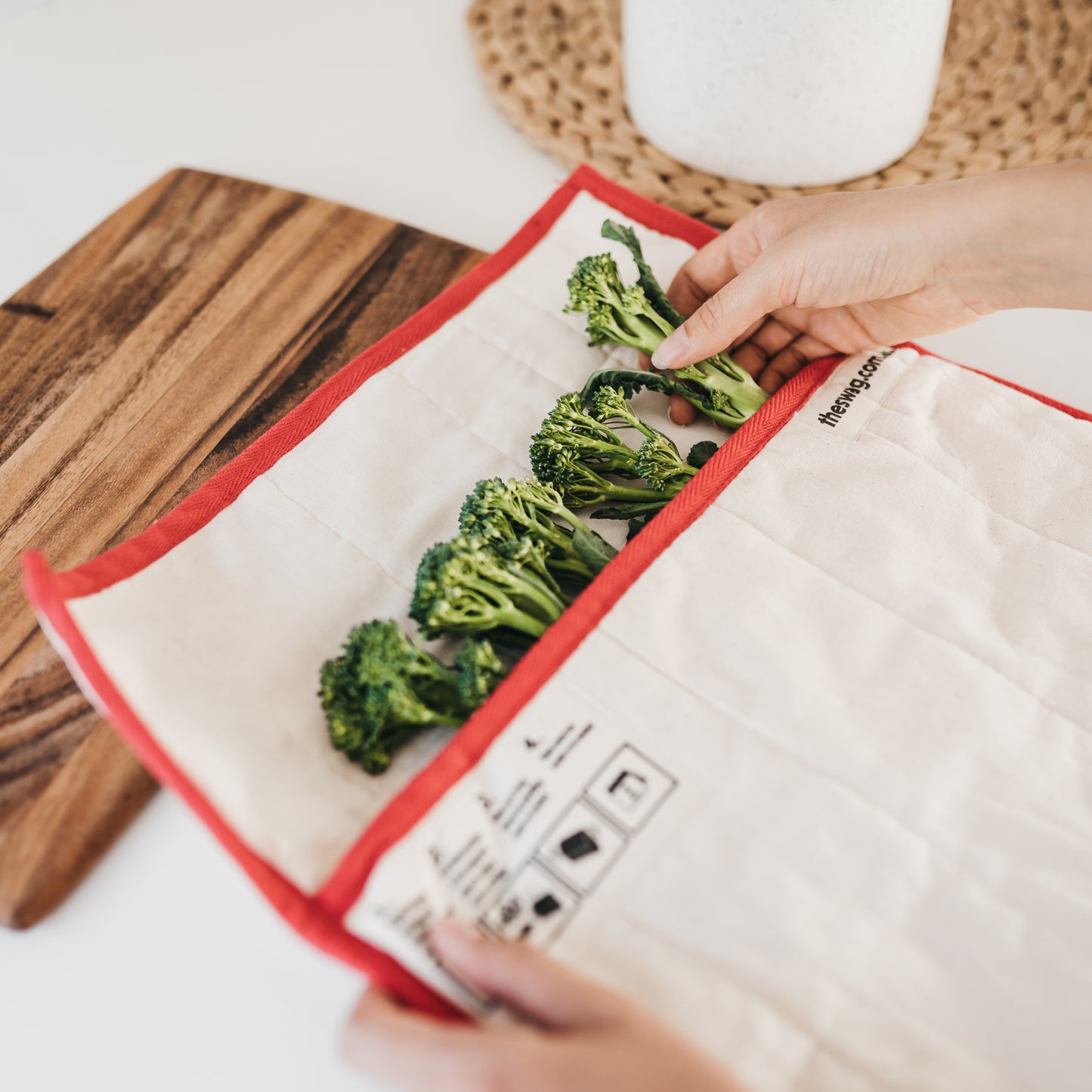 The Swag Small Reusable Swag Fridge bag with orange trim showing hands putting broccoli into The Swag bag - The Swag AU